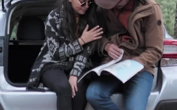 Stock Video Couple Watching A Map In The Trunk Of A Car For PC