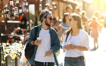 Stock Video Couple Stroll Down Sunny Street With Coffee For PC