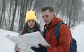 Stock Video Couple Checking Map On Hike In Snowfall For PC