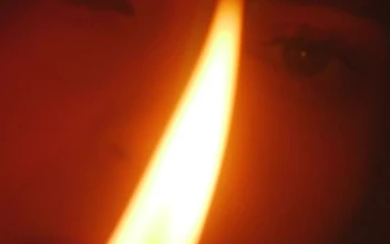 Stock Video Face Of A Young Woman Appreciating The Flame Of A For PC