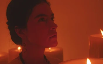 Stock Video Face Of A Spiritual Woman Meditating Among Many Candles For PC