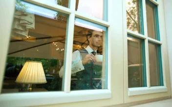 Stock Video Elegant Man Drinking From A Mug While Looking Out For PC