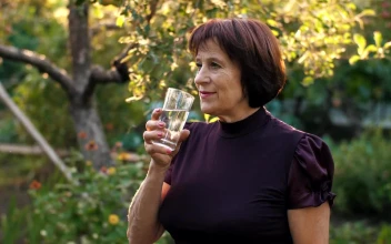 Stock Video Elderly Woman Drinking Water In Her Home Garden For PC