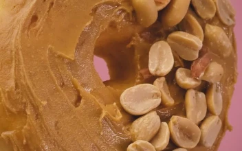 Stock Video Donut With Peanut Butter And Peanuts On A Pink Background For PC
