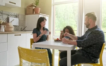 Stock Video Diverse Race Family Sit At Kitchen Table Drinking Coffee For PC