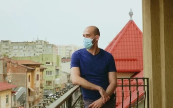 Stock Video Depressed Man Stands On Balcony In Face Mask For PC