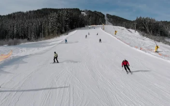 Stock Video Flying Over Skiers Going Down The Snowy Moountain For PC