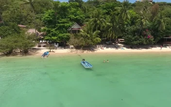 Stock Video Flying Over A Tourist Beach With Bungalows For PC