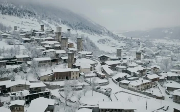 Stock Video Flying Above A Town With Old Towers Covered In Snow For PC