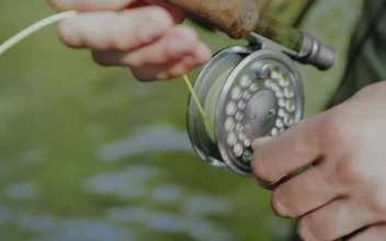 Stock Video Fisherman Rolling The Line Spool For PC