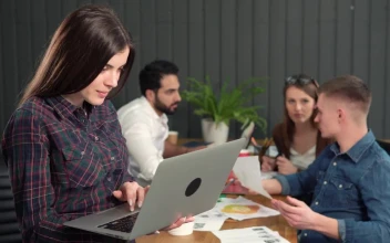 Stock Video Female Team Leader Holding Laptop Turns And Smiles For PC