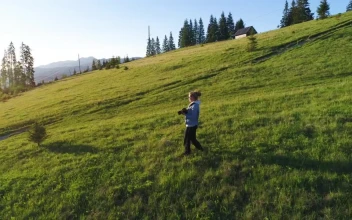 Stock Video Female Photographer Walking Down A Hill And Taking Photos For PC