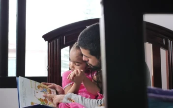Stock Video Father With His Daughter In His Arms Reads A Childrens For PC