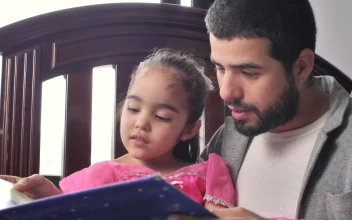 Stock Video Father Reading A Story To His Daughter In His Arms For PC
