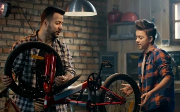 Stock Video Father And Son Repairing A Wheel Of A Bike For PC