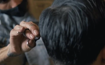 Stock Video Hairdresser With A Mask Cutting A Persons Hair For PC