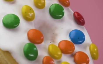 Stock Video Glazed Donut With Colored Chocolates On A Pink Background For PC