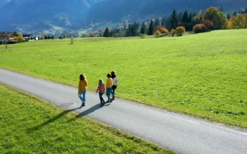 Stock Video Girls Walking On A Road Between Grass Fields For PC