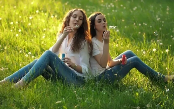 Stock Video Girlfriends Sitting In A Meadow Blowing Bubbles For PC