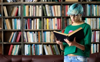Stock Video Girl With Glasses Reading A Book In A Library For PC