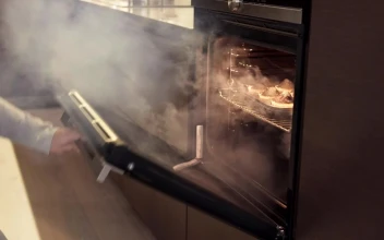 Stock Video Girl Taking Burnt Food Out Of An Oven For PC