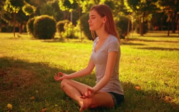 Stock Video Girl Meditating In Yoga Pose In A Park For PC