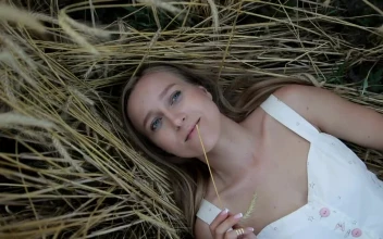 Stock Video Girl Lying On Straw In A Spinning Portrait For PC