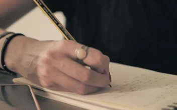 Stock Video Girl In Glasses Writing With Pencil On A Notepad For PC