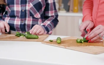 Stock Video Girl Helps Mom Chop Vegetables In Kitchen For PC