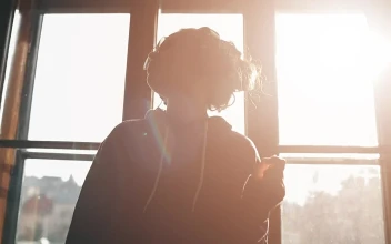 Stock Video Girl Enjoying Music Dances By Sunlit Window For PC