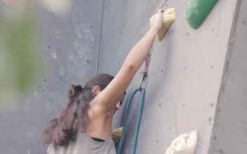 Stock Video Girl Climbing To The Top Of A Mountaineering Wall For PC
