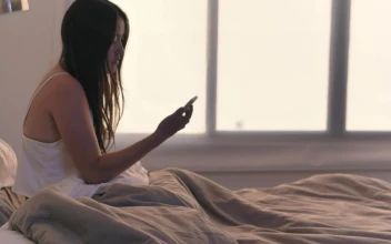 Stock Video Girl Checking Her Cell Phone In Her Bed Upon Waking For PC