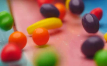 Stock Video Fruit Shaped Sweets Slowly Falling Into A Bowl For PC