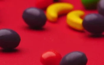 Stock Video Fruit Shaped Sweets Rolling On A Red Surface For PC