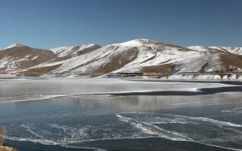 Stock Video Frozen Water Surface Of A Lake Near The Mountains For PC