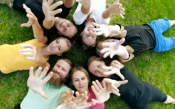 Stock Video Friends Lying On The Grass Waving At The Camera For PC