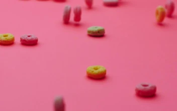 Stock Video Hoop Cereal Gliding On A Pink Surface Animated Wallpaper