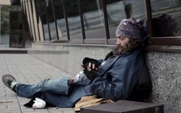 Stock Video Homeless Man Checking The Mobile Phone On The Sidewalk Animated Wallpaper
