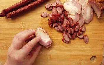 Stock Video Hands Of A Person Cutting Sausages On A Board Animated Wallpaper