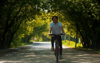 Stock Video Man In Riding A Bike Stops To Put On His Animated Wallpaper