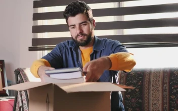 Stock Video Man In His Living Room Finishes Packing A Box To Animated Wallpaper