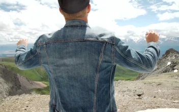 Stock Video Man In Denim Jacket Raises Arms To Mountain Landscape Animated Wallpaper