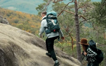 Stock Video Man Helps Girlfriend Climb Up Rock During Hike Animated Wallpaper