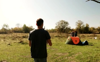 Stock Video Man Helps Friends Start Fire On Camping Trip Animated Wallpaper