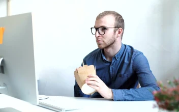 Stock Video Man Eats Take Out Food At Desk In Minimal Office Animated Wallpaper