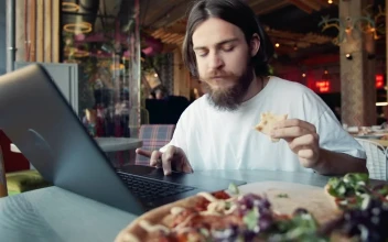 Stock Video Man Eats Pizza While Woking On Laptop At Hip Cafe Animated Wallpaper