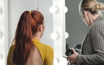 Stock Video Makeup Artist Putting Makeup On A Model In Front Of Animated Wallpaper