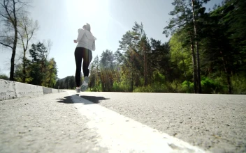 Stock Video Low Angle Of Runner Jogging On Forest Road Animated Wallpaper