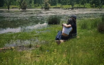 Stock Video Loving Couple Sitting On The Shore Of A Lake Outdoors Animated Wallpaper