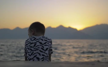 Stock Video Lonely Boy Sitting On The Seashore Animated Wallpaper